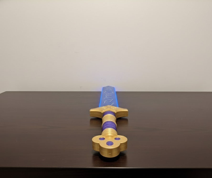 Toy sword with blue blade and gold handle on a dark surface