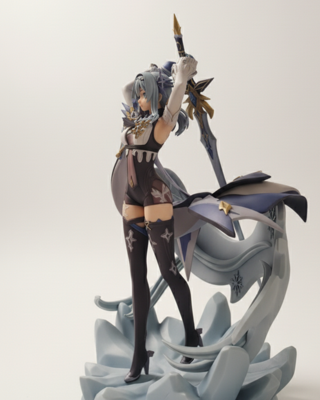 Figurine of a character with gray hair and a weapon on a white background